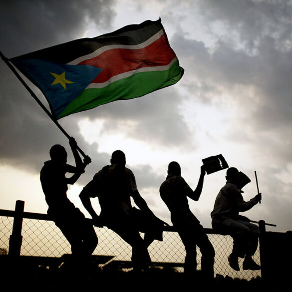 Southern Sudanese wave flags and cheer at the Republic of South Sudan's first national soccer match in the capital of Juba on Sunday, July 10, 2011. The game, played against Kenya, comes just one day after South Sudan declared its independence from the north following decades of costly civil war. (AP Photo/Pete Muller)